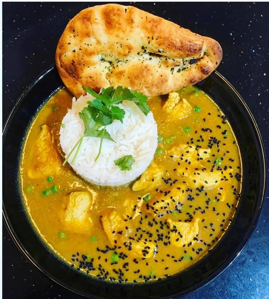 Chicken in vegetable curry sauce with toasted garlic naan and rice